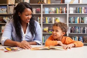 Teacher and child at a table reading