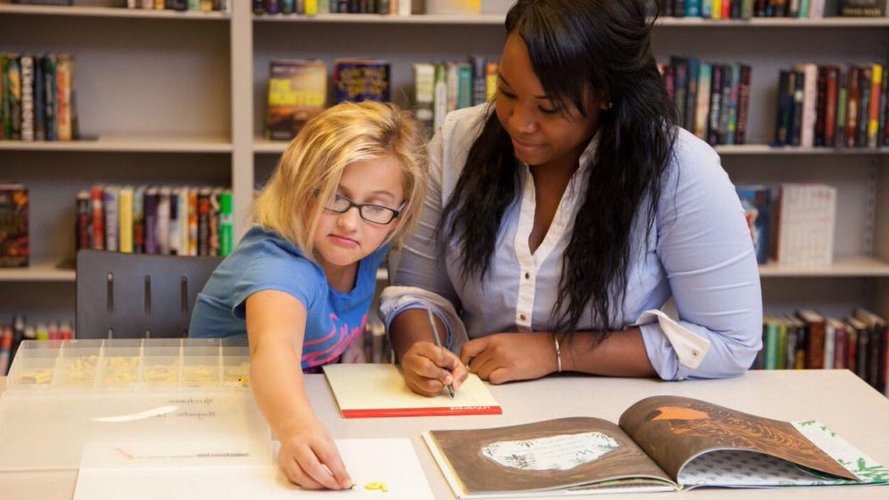 A woman teaching a young girl